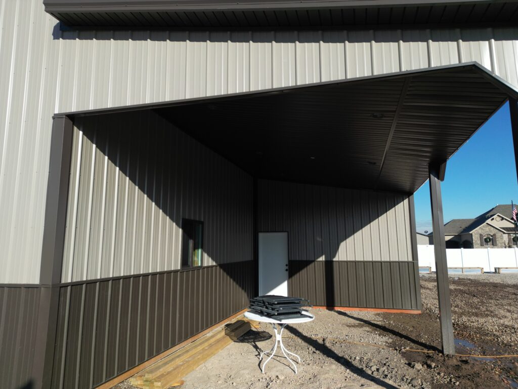 Open lean-to on a pole barn featuring detailed soffit on the ceiling, showcasing intricate design and functional outdoor space.