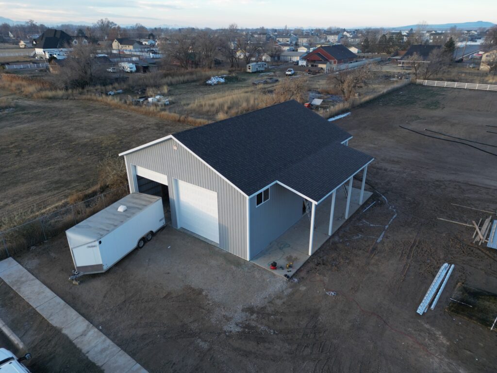 Aerial view captured by a drone, showcasing a sprawling, well-constructed pole barn with surrounding landscape.