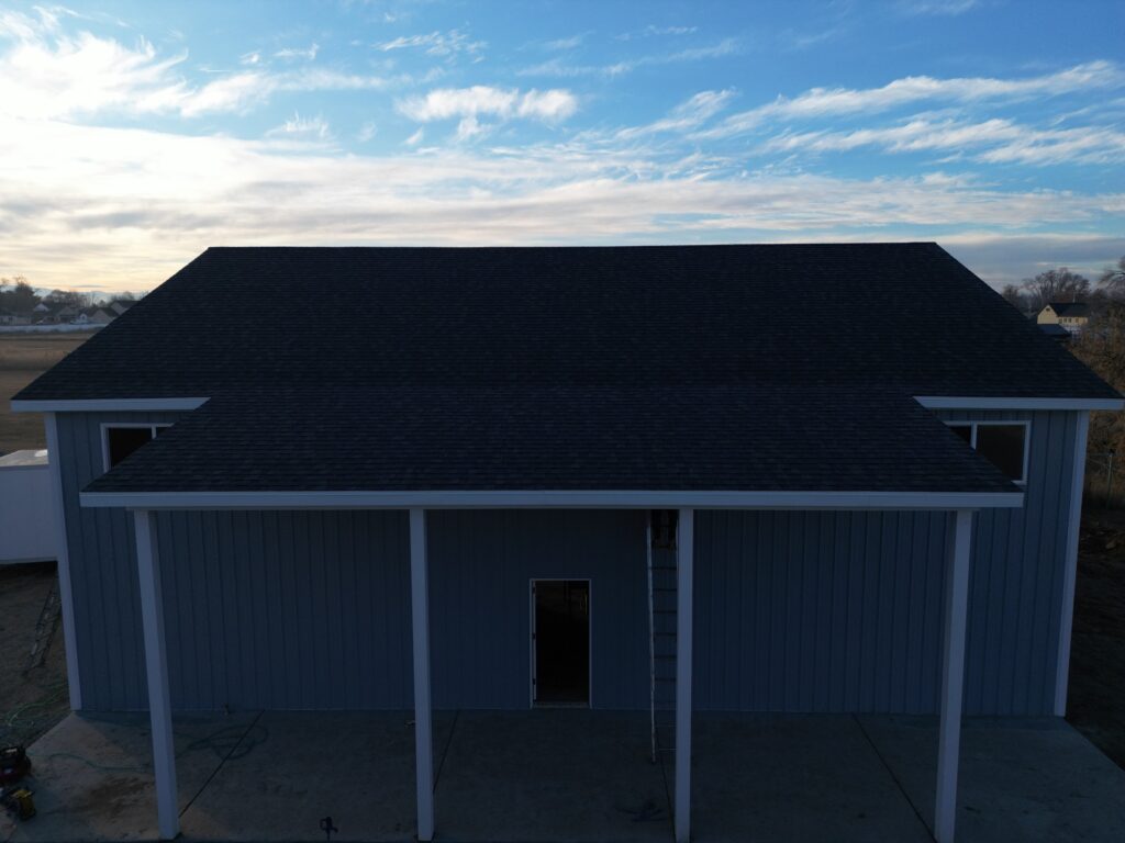 Lean-to extension on a pole barn featuring a continuous sloped roof and matching siding, seamlessly integrated with the main structure.